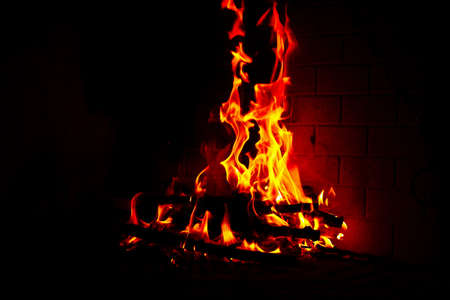 High flame of wood fire into a fireplace in a cold winterの写真素材