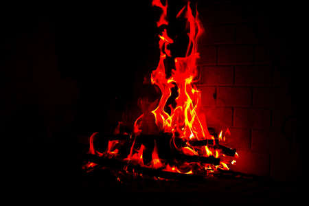 High flame of wood fire into a fireplace in a cold winterの写真素材