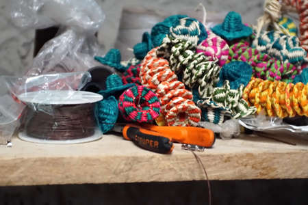 Tiny woven straw hats on a work bench in a tagua nut jewelry factory Iluman, Ecuador