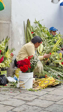 Woman selling flower arrangements for Palm Sunday on the sidewalk in Cuenca, Ecuadorのeditorial素材