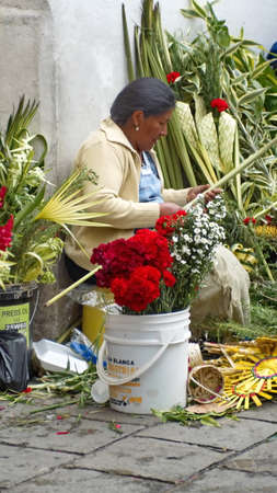 Woman selling flower arrangements for Palm Sunday on the sidewalk in Cuenca, Ecuadorのeditorial素材