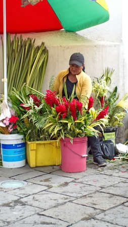 Woman selling flower arrangements for Palm Sunday on the sidewalk in Cuenca, Ecuadorのeditorial素材