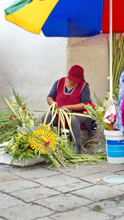 Woman selling flower arrangements for Palm Sunday on the sidewalk in Cuenca, Ecuadorのeditorial素材
