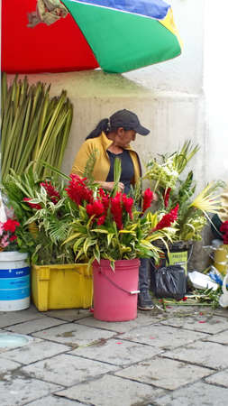Woman selling flower arrangements for Palm Sunday on the sidewalk in Cuenca, Ecuadorのeditorial素材