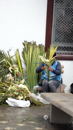Woman selling flower arrangements for Palm Sunday on the sidewalk in Cuenca, Ecuadorのeditorial素材