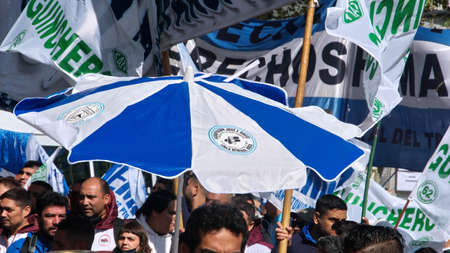 People marching with blue and white banners and umbrellas on the Day of Remembrance in Buenos Aires, Argentinaのeditorial素材