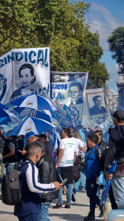 People marching with blue and white banners and umbrellas on the Day of Remembrance in Buenos Aires, Argentinaのeditorial素材