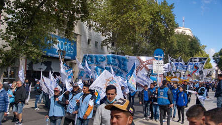 People marching with blue and white banners and umbrellas on the Day of Remembrance in Buenos Aires, Argentinaのeditorial素材