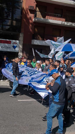 People marching with blue and white banners and umbrellas on the Day of Remembrance in Buenos Aires, Argentinaのeditorial素材