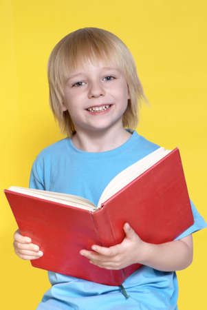 Portrait of the nice schoolboy on a yellow background