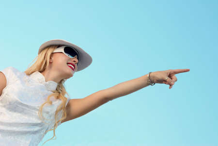 The stylish blonde in a cap against  skyの写真素材