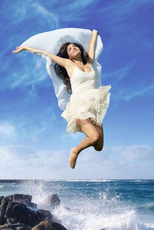 The young girl in a jump on seacoastの写真素材