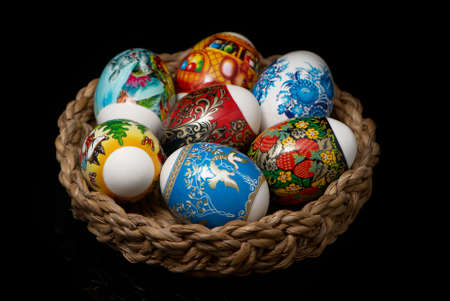 Easter Eggs in wicker basket on black backgroundの写真素材