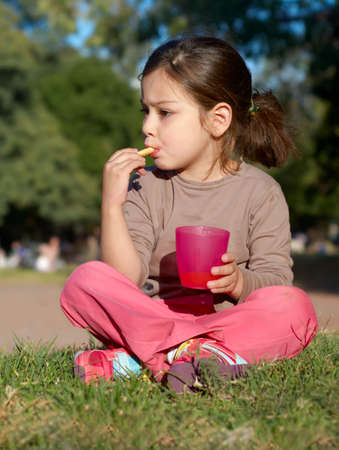 The little girl having a rest on a glade in parkの写真素材
