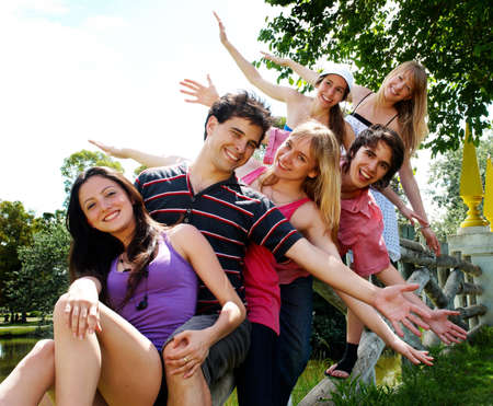 happy group of friends smiling outdoors in a parkの写真素材