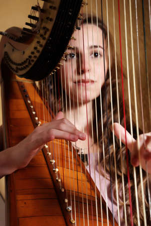 Female musician playing the harpの写真素材