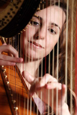 Female musician playing the harpの写真素材