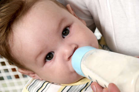 Portrait baby drinking milk of her bottleの写真素材