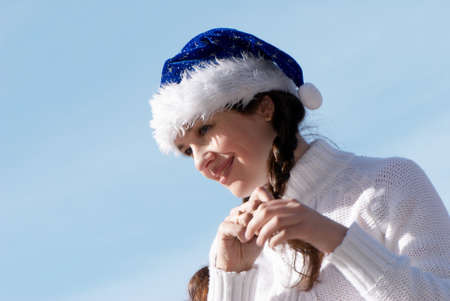 The girl in a New Year's cap against sky