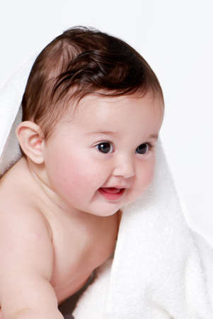 Portrait of the little baby under a terry towel の写真素材