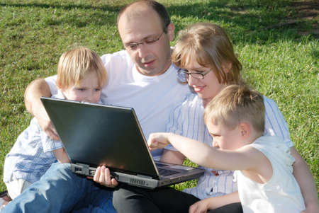 Family in park studying the laptopの写真素材