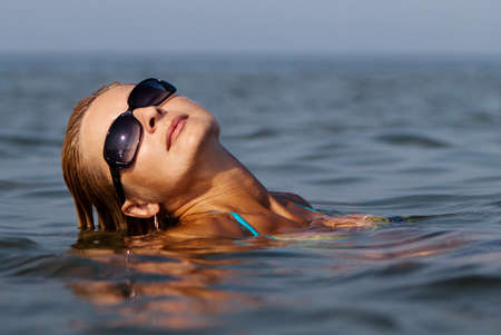 Happy young woman in sea の写真素材