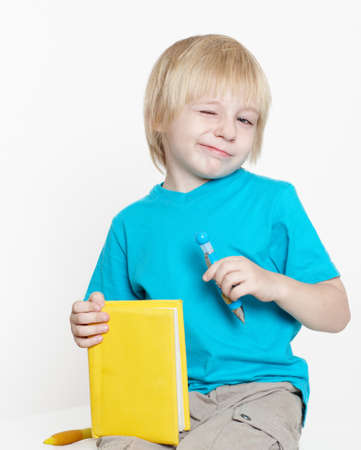 The boy of preschool age with book on a light background