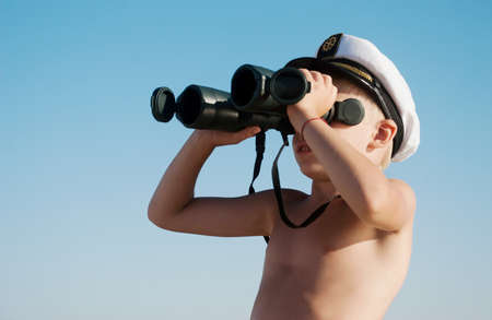 Little cute child with binoculars outdoor の写真素材