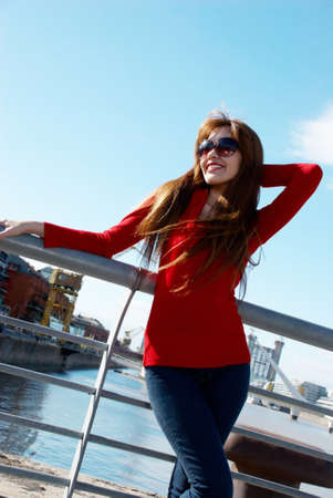 The young woman in sunglasses looking in a skyの写真素材
