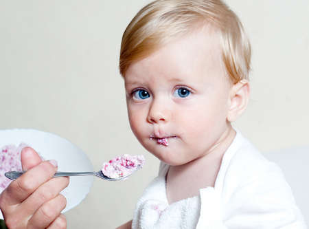 Little boy eating baby food with spoonの写真素材