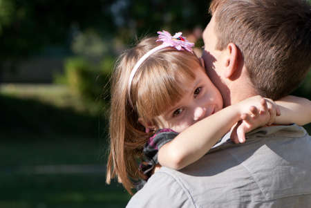 The small happy girl on a shoulder of the fatherの写真素材