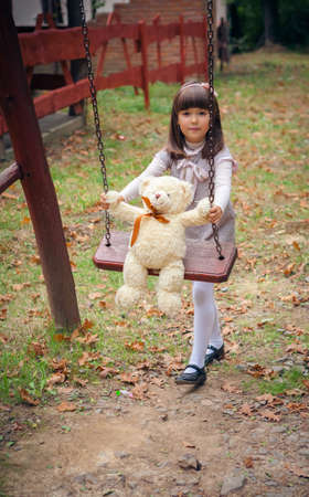 Small beautiful girl and amusing bearの写真素材
