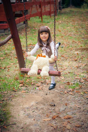 Small beautiful girl and amusing bearの写真素材