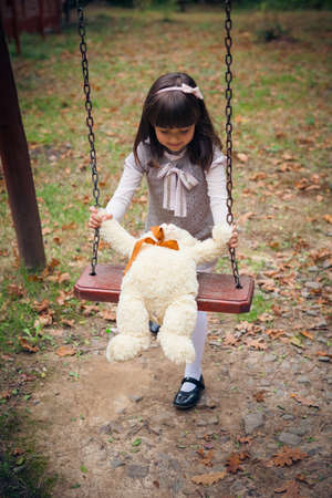 Small beautiful girl and amusing bearの写真素材