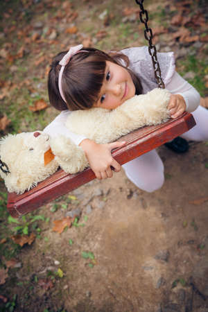 Small beautiful girl and amusing bearの写真素材