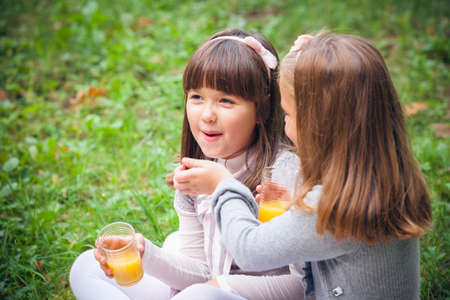 Happy little girlfriends in parkの写真素材