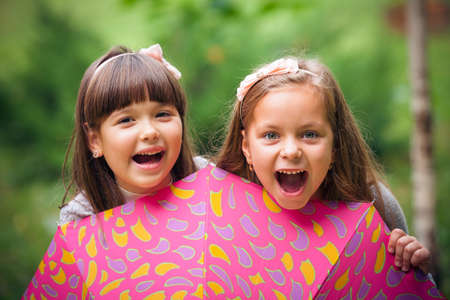 Happy little girlfriends in parkの写真素材