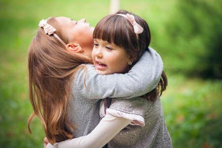 Happy little girlfriends in parkの写真素材