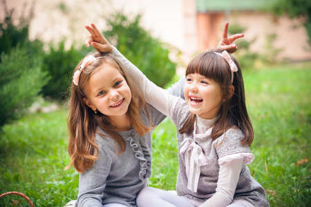 Happy little girlfriends in parkの写真素材