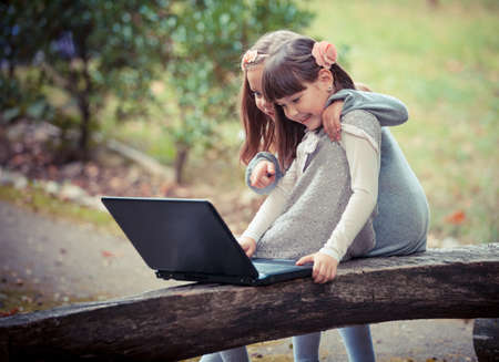 girlfriend in autumn park with laptopの写真素材