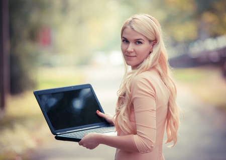 Cute woman with laptop in the parkの写真素材