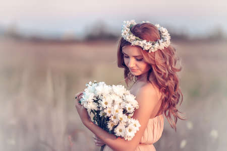 beautiful girl in a camomile wreathの写真素材