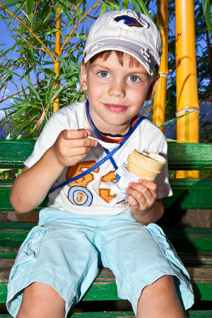 small boy kid on nature eats ice creamの写真素材