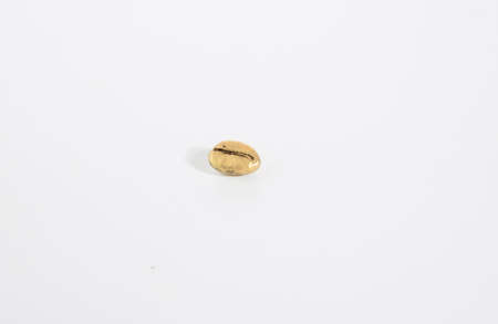 gold shiny coffee bean isolated on white backgroundの写真素材
