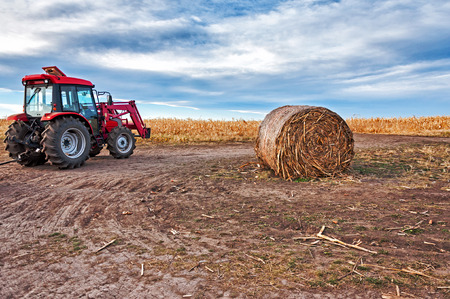 Tractor on corn field and hayの写真素材