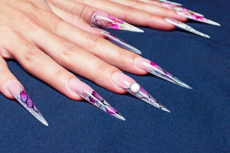 Very long artificial nails at dark backgroundの写真素材
