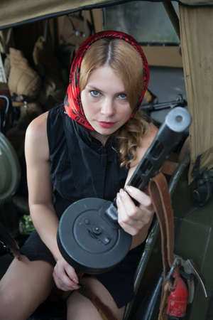 The girl sitting in a car with a rifle in his hand 