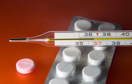 Tablets and thermometer. One tablet is separately. At normal temperature thermometer.の写真素材