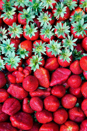 Strawberries with leaves laid on the tray and ready for sale.