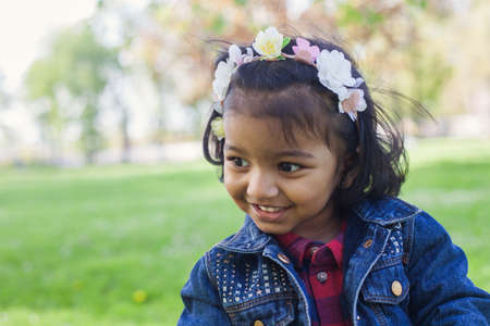 A happy south asian girl is walking in city parkの写真素材